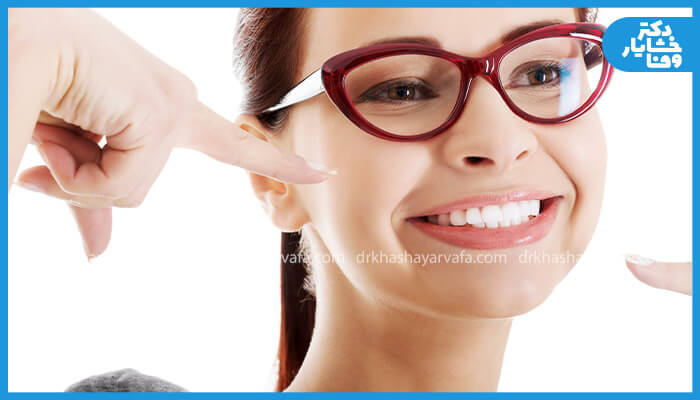 زنی خندان با عینک که پس از اصلاح طرح لبخند، رضایت و شادی خود را نشان میدهد.