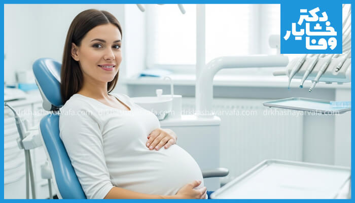 خانم بارداری در حال معاینه دندانپزشکی در مطب نشسته و لبخند میزند